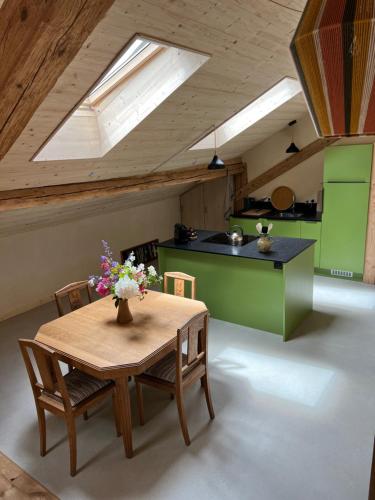 une cuisine avec une table avec un vase de fleurs dessus dans l'établissement Le gîte Samezo, à Villers-le-Lac