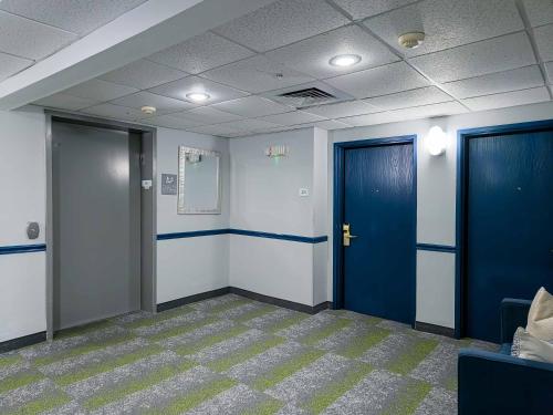 an empty room with two blue doors and a carpet at Spark by Hilton Montgomery EastChase in Montgomery