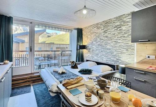 - une cuisine avec un lit au milieu d'une pièce dans l'établissement Résidence Les Hauts Lieux - Joli studio cabine 4 personnes à Tignes au pied des commerces et proche des pistes,avec vue imprenable sur le lac et le glacier MAE-2634, à Tignes