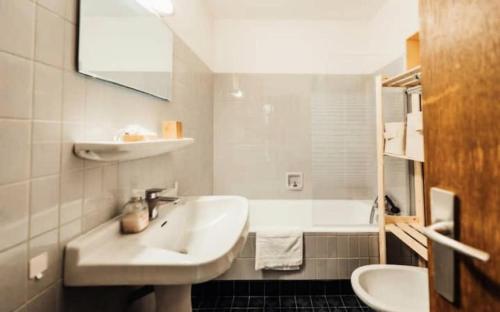 La salle de bains blanche est pourvue d'un lavabo et d'une baignoire. dans l'établissement Résidence Soleil D'arbois - Anemones - Soleil d'Arbois Anémones 507 MAE-7774, à Saint-Gervais-les-Bains