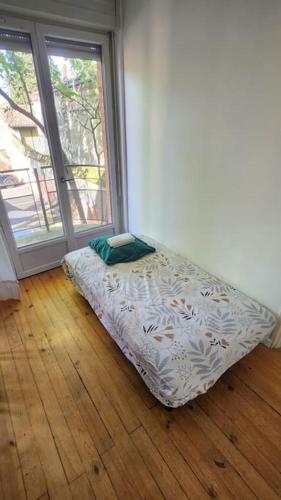 - un lit dans l'angle d'une chambre avec fenêtre dans l'établissement T3 Petit Confort - proche commodités - Parking privé, à Toulouse