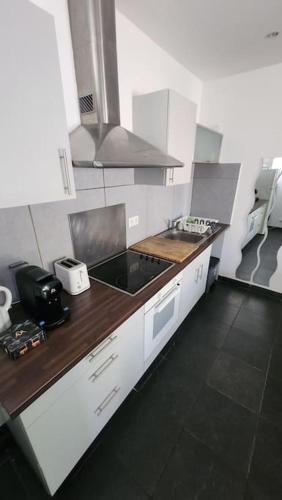 une cuisine avec des armoires blanches et un comptoir dans l'établissement T3 Petit Confort - proche commodités - Parking privé, à Toulouse