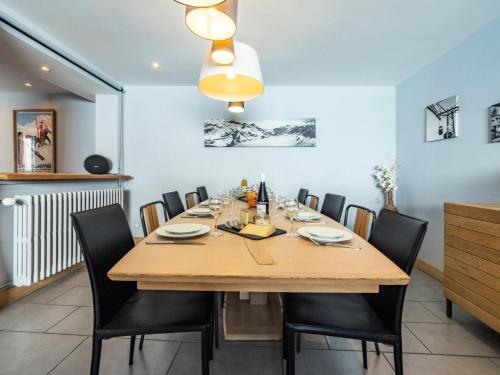 une salle à manger avec une table en bois et des chaises noires dans l'établissement Chalet Millonex - Duplex rénové·skis aux pieds·WIFI·Cheminée MAE-4964, à Tignes