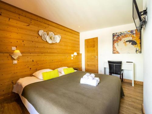 a bedroom with a large bed with a wooden wall at Chalet Millonex - Appartement rénové·skis aux pieds·WIFI·Balcon MAE-4984 in Tignes
