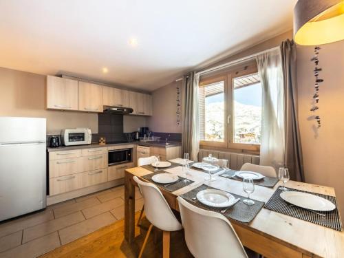 - une cuisine avec une table à manger et des appareils électroménagers blancs dans l'établissement Chalet Millonex - Appartement rénové·skis aux pieds·WIFI·Balcon MAE-4984, à Tignes
