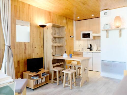Il comprend une cuisine dotée de murs en bois, d'une table et d'un réfrigérateur. dans l'établissement Résidence Savoy - Studio lumineux·Proche des pistes et des commerces MAE-7194, à Tignes