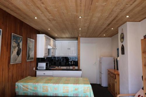 une cuisine avec des armoires blanches et un plafond en bois dans l'établissement Résidence 2100b - Appartement confortable·Proches de pistes·Balcon MAE-6674, à Tignes
