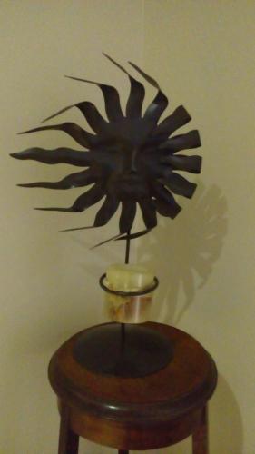 a metal sculpture of a sun on a wall at Casa 24 Puerto Iguazu in Puerto Iguazú