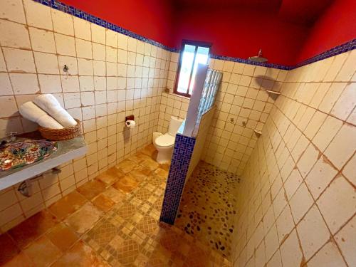 a bathroom with a toilet and a sink at Kudos Boutique Hotel in Cabrera