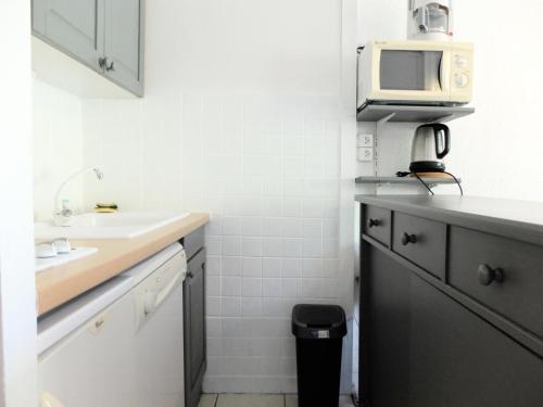 une petite cuisine avec un évier et un micro-ondes dans l'établissement Résidence Moutieres B1 - Studio·Proche des pistes·Balcon MAE-3984, à Tignes