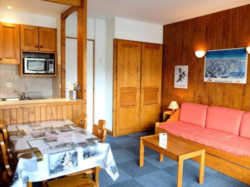 un salon avec un canapé rouge et une table dans l'établissement Résidence Bec Rouge - Appartement lumineux·Accès direct pistes·Balcon MAE-7464, à Tignes