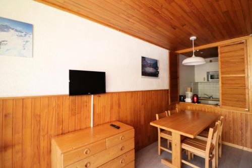 une salle à manger avec une table et une télévision au mur dans l'établissement Résidence Hauts Du Val Claret B2 - Studio confortable · Entre pistes et commerces MAE-3644, à Tignes