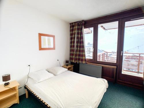 une chambre avec un lit et une grande fenêtre dans l'établissement Résidence Curling B1-b2 - Deux pièces avec balcon exposé Sud MAE-2754, à Tignes