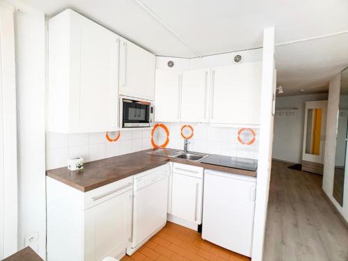 une cuisine avec des armoires blanches et un évier dans l'établissement Résidence Palafour - Appartement , au Lac, skis au pied MAE-7314, à Tignes