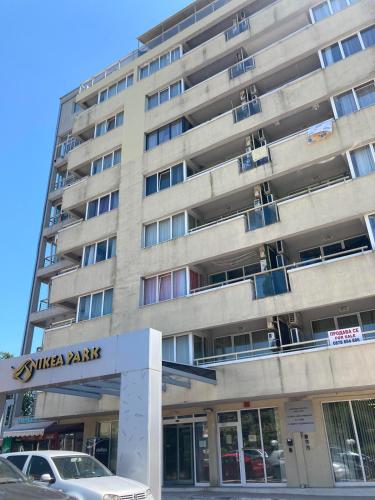 a large building with a parking lot in front of it at Milushevi apartment in Golden Sands