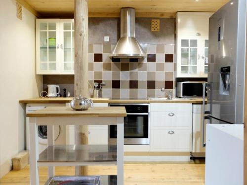 une cuisine avec des armoires blanches et un réfrigérateur en acier inoxydable dans l'établissement Résidence Lot 300 - Appartement spacieux et renové MAE-0524, à Tignes