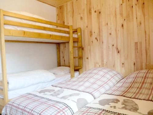 Ce lit se trouve dans un dortoir doté de 2 lits superposés et de murs en bois. dans l'établissement Résidence Lot 300 - Appartement spacieux et renové MAE-0524, à Tignes