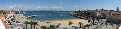 a beach with a group of people in the water at Apartment Outeiro da Vela in Cascais