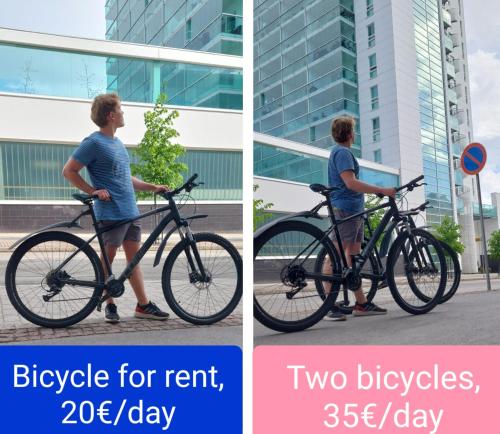a man standing with two bikes on a street at 3-Room Central Railway station in Oulu