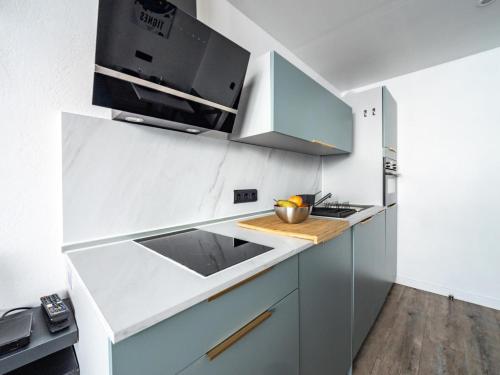 - une cuisine avec des placards blancs et bleus et un évier dans l'établissement Résidence Home Club - Studio confortable · Skis aux pieds · Balcon MAE-0264, à Tignes