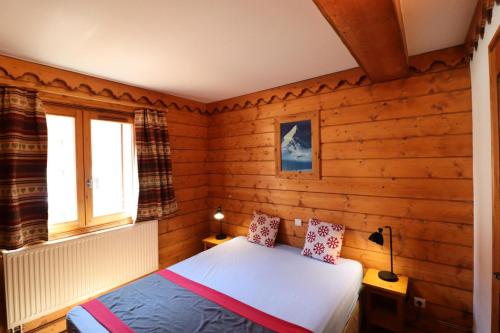 une chambre avec un lit dans une pièce aux murs en bois dans l'établissement Résidence Ecrin Des Neiges - Bel appartement 4 pièces au Val claret MAE-3974, à Tignes