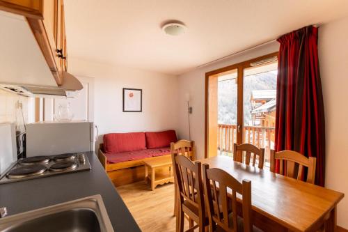 une cuisine et un salon avec une table et un canapé dans l'établissement Les Chalets De Bois MÉan - C - Appartement sur les hauteurs des Orres 1800 MAE-6034, aux Orres