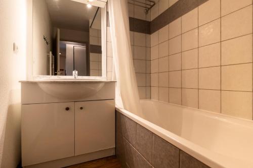 une salle de bain avec un lavabo et une baignoire dans l'établissement Les Chalets De Bois MÉan - C - Appartement sur les hauteurs des Orres 1800 MAE-6034, aux Orres