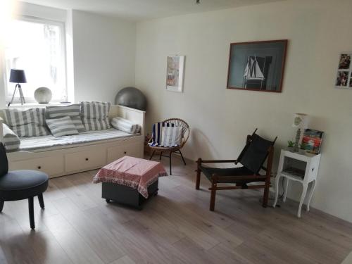 un salon avec un canapé et deux chaises dans l'établissement Maison de bourg proche plages, à Ploeren