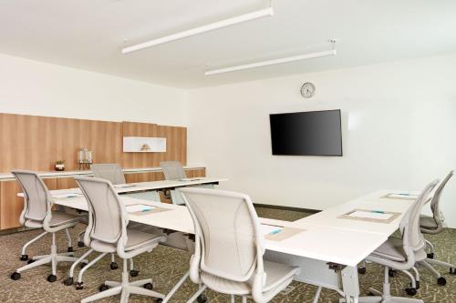 a conference room with tables and chairs and a tv at Element Cartersville in Cartersville