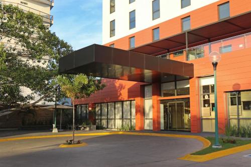 an office building with a black object on the facade at City Express Plus by Marriott Puerto Vallarta in Puerto Vallarta