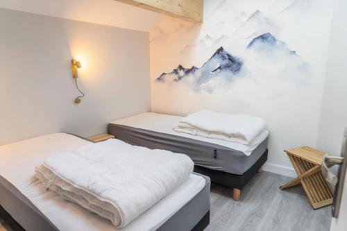 deux lits dans une chambre avec un tableau au mur dans l'établissement Les Chalets De Bois MÉan - D - Magnifique appartement avec vue sur la vallée MAE-9374, aux Orres