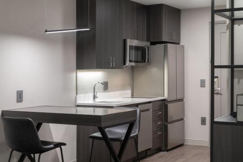 a kitchen with a sink and a counter with two chairs at Residence Inn by Marriott Annapolis in Annapolis