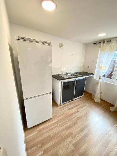 cocina con nevera blanca y suelo de madera en Danielle et octave, en Clermont