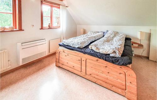 a bedroom with a bed with a wooden frame at Amazing Home In Örkelljunga With Sauna in Orkelljunga