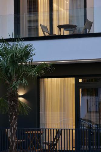 a palm tree sitting on the balcony of a house at Austin Boutique Hotel in Sarandë