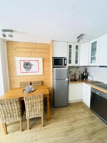 - une cuisine avec une table en bois et un comptoir dans l'établissement Curling A - Bel appartement confortable ski aux pieds MAE-6504, à Tignes