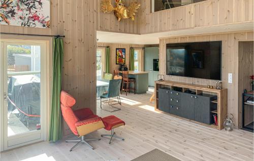 a living room with a flat screen tv and a chair at Beautiful Home In Risør With Kitchen in Risør