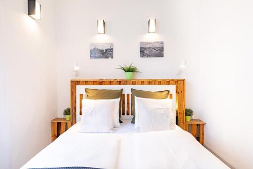 Un dormitorio con una cama con sábanas y almohadas blancas. en Central Comfy Home, en Budapest