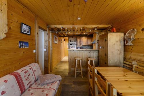 - une salle à manger et une cuisine dans une cabane en rondins dans l'établissement Résidence FlÈche - 2 Pièces pour 6 Personnes 944, à Aime La Plagne