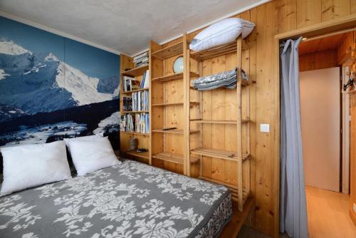 une chambre avec un lit et une étagère dans l'établissement Résidence FlÈche - 2 Pièces pour 6 Personnes 944, à Aime La Plagne
