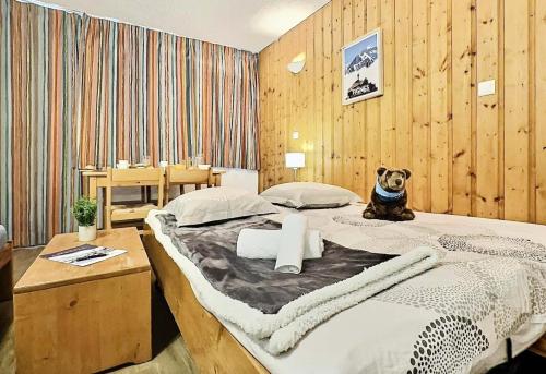 - une chambre avec un chien assis sur un lit dans l'établissement Résidence Home Club - Studio 4 personnes + parking au coeur du Lavachet MAE-2954, à Tignes