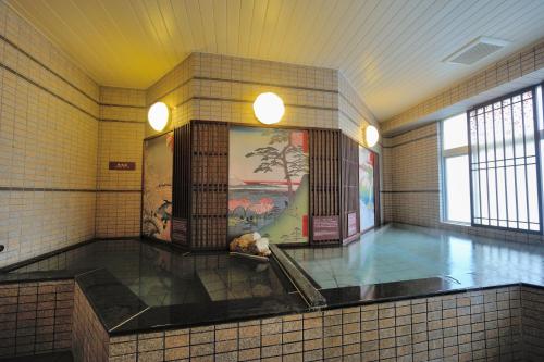 a large bathroom with a tile floor and a painting on the wall at Dormy Inn Express Meguro Aobadai Hot Spring in Tokyo