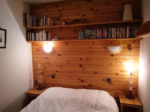 - une chambre dotée d'un mur en bois avec un lit et des étagères dans l'établissement Résidence Les Glaciers 3 - 2 Pièces pour 5 Personnes 214, à Aime La Plagne