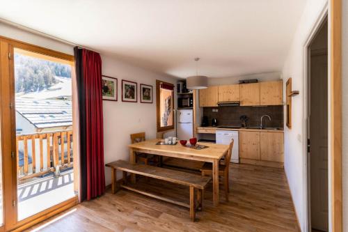 une cuisine avec une table et une vue sur un balcon dans l'établissement Les Chalets De Bois MÉan - A - Magnifique appartement montagnard aux Orres 1800 MAE-6521, aux Orres