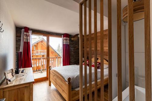 une chambre avec un lit et une grande fenêtre dans l'établissement Les Chalets De Bois MÉan - C - Magnifique appartement montagnard aux Orres 1800 MAE-6531, aux Orres