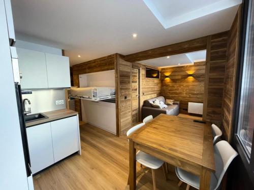une cuisine et une salle à manger avec une table et des chaises en bois dans l'établissement Résidence Rond Point Des Pistes A - Appartement 2 pèces rénové, pieds des pistes MAE-2861, à Tignes