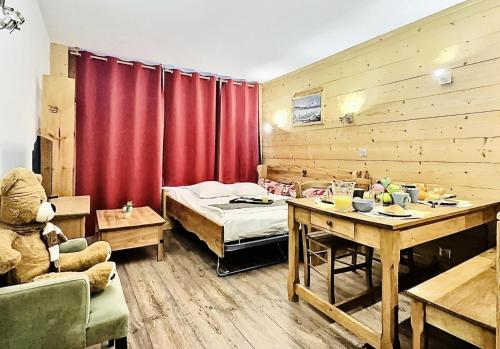 Cette chambre comprend un lit et une table avec un ours en peluche. dans l'établissement Résidence Le Slalom - Sublime T2 tout confort entièrement rénové à deux pas du centre du Val Claret MAE-2661, à Tignes