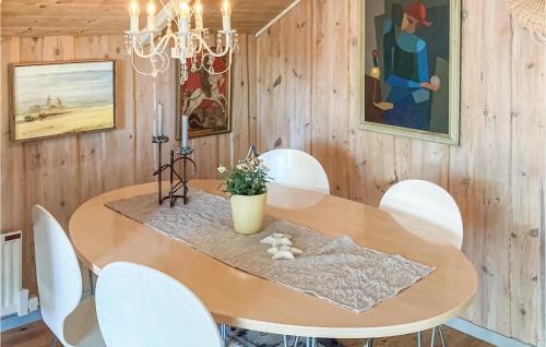a dining room with a wooden table and white chairs at Lovely Home In Heberg With Sauna in Heberg
