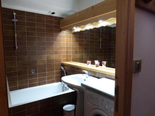 une salle de bain avec un lavabo et une baignoire dans l'établissement Résidence Les Dauphinelles - Agréable studio à Méribel Altiport proche des pistes MAE-7641, à Les Allues