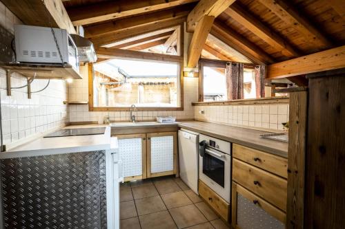 une cuisine avec un évier et une cuisinière dans l'établissement Les Chalets Du Cocoon - 6 Pièces pour 11 Personnes 611, à Aime La Plagne